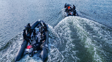 Frogmen manipulate combat rubber raiding crafts to designated waters