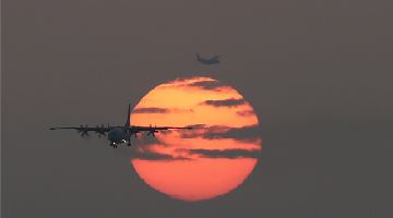 Reconnaissance aircraft fly past setting sun 